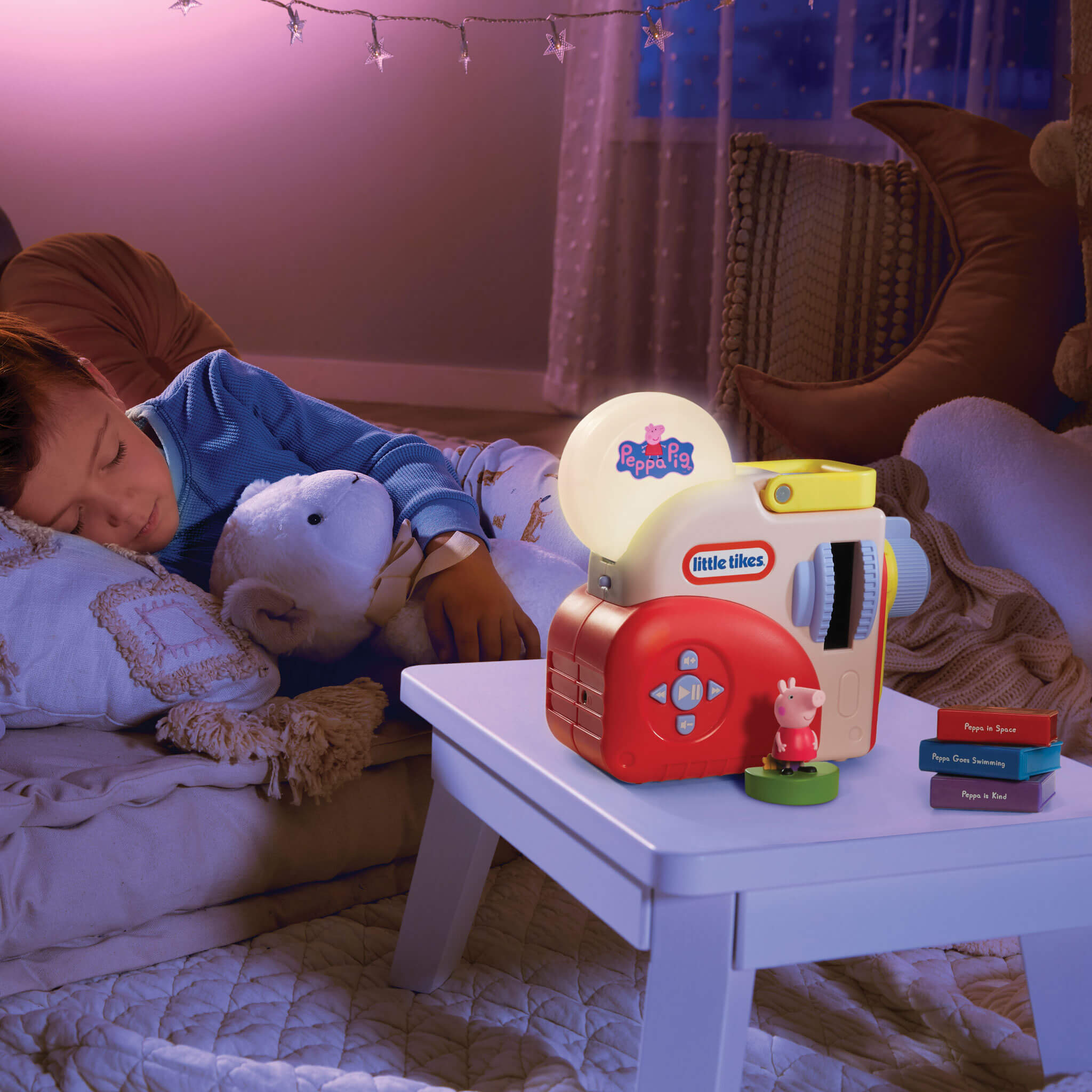 Child sleeping with a teddy bear next to a Little Tikes night light on a table.